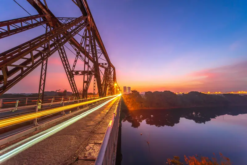 Long Bien Bridge in Hanoi at sunset, with light trails on the road